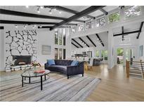 Bright living room with stone fireplace, wood floors, and floor-to-ceiling windows showing lots of natural light at 3165 Brookview Dr, Marietta, GA 30068