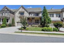Charming two-story home with stone accents, covered porch, and well-manicured landscaping at 12095 Cameron Dr, Duluth, GA 30097