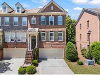 Charming brick townhome with a two-car garage and inviting front entrance with dark shutters and trim at 1667 Wehunt Se Pl # 11, Smyrna, GA 30082