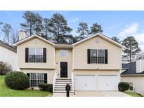 Charming two-story home with a well-maintained lawn and a two-car garage at 820 Tradd Ct, Stone Mountain, GA 30087