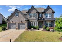 Beautiful two-story brick home with a well-manicured lawn and attached two-car garage at 7575 Old Camp Lndg, Cumming, GA 30040