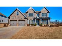 Charming two-story brick home with a manicured lawn and a two-car garage in a sought-after community at 7575 Old Camp Lndg, Cumming, GA 30040