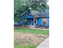 Charming blue house featuring a covered front porch and a well-maintained lawn at 483 Glen Terrace Rd, Auburn, GA 30011