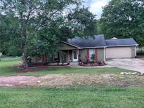 Charming single-story home with a well-maintained front yard, a large tree, and an attached two-car garage at 483 Glen Terrace Rd, Auburn, GA 30011