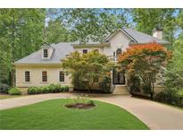 Stunning stucco home with manicured lawn and mature trees, showcasing curb appeal at 200 River Pass Trl, Atlanta, GA 30350