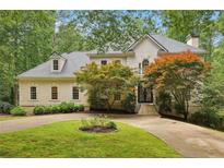 Charming two-story traditional home with a circular driveway and lush, mature landscaping at 200 River Pass Trl, Atlanta, GA 30350