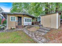 Charming home featuring a lovely yard, stone walkway, and shed at 5400 Kings Camp Rd Se #C1 Se Rd, Acworth, GA 30102