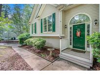 Charming home featuring a green front door with decorative wreath, surrounded by manicured landscaping and green shutters at 90 Camden Woods Pl, Dallas, GA 30157