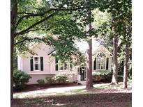 Charming home with green shutters and mature trees in a tranquil, wooded setting at 90 Camden Woods Pl, Dallas, GA 30157