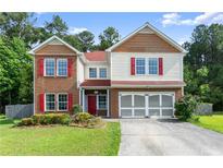 Charming two-story home featuring a brick and siding exterior with a well-maintained lawn and mature trees at 3235 Avondale Pkwy, Powder Springs, GA 30127