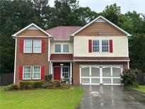Charming two-story home with brick and siding exterior, red shutters, and well-maintained landscaping at 3235 Avondale Pkwy, Powder Springs, GA 30127
