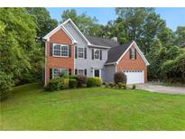 Charming two-story home features manicured landscaping and an attached two-car garage at 5705 Cannonero Dr, Alpharetta, GA 30005