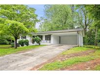 Charming brick home with a carport, landscaped yard, and a long driveway at 1780 Kinridge Rd, Marietta, GA 30062