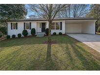 Charming home with a well-manicured lawn, white brick, a covered parking area, and black shutters at 1780 Kinridge Rd, Marietta, GA 30062