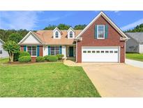 Charming brick and vinyl home featuring a well-manicured lawn and two-car garage at 2620 Matlin Way, Buford, GA 30519
