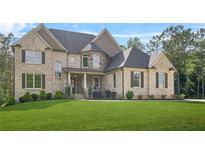 Stunning brick home featuring a manicured lawn and classic architectural details at 3298 Alcovy Club Ct, Dacula, GA 30019