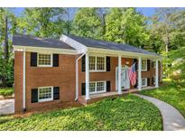 Charming two-story brick home featuring classic architecture, black shutters, and a welcoming front porch at 4331 E Kings Point Circle, Dunwoody, GA 30338