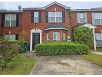 Traditional brick townhome with a well-manicured lawn and black shutters at 5536 Strathmoor Manor Cir, Lithonia, GA 30058