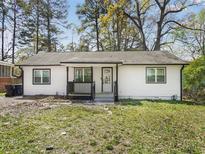 Charming single-story home featuring a tidy lawn and freshly painted black and white exterior at 117 Spring St, Stockbridge, GA 30281