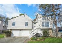Charming two-story home featuring a well-manicured lawn, attached two-car garage and a mix of horizontal and vertical siding at 3813 Nowlin Nw Rd, Kennesaw, GA 30144