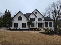 Stunning two-story home with a black roof, white facade, manicured lawn, and circular driveway at 7910 Tintern Trce, Duluth, GA 30097