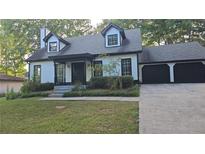 Charming home with a two-car garage and a well maintained lawn at 1947 Kensington High Sw St, Lilburn, GA 30047