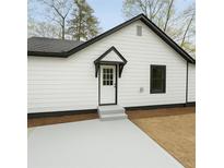 Charming home featuring a black and white exterior, covered front door, and newly installed concrete at 1691 Flat Shoals Rd, Atlanta, GA 30316