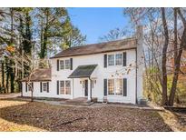 Charming two-story home with white siding, black shutters, and a well-manicured front yard at 7935 Sweetwater Dr, Douglasville, GA 30135