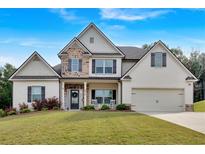 Charming two-story home with painted brick, stone accents, manicured lawn and front porch at 4575 Birch Way, Loganville, GA 30052