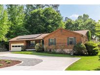 Charming wood and stone home featuring an attached garage, well-manicured lawn and a driveway at 522 Knollwood Dr, Stockbridge, GA 30281