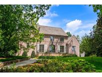Elegant brick home featuring manicured landscaping, a lush lawn, and mature trees on a sunny day at 2515 Habersham Rd, Atlanta, GA 30305