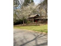 Quaint home with a red door and blooming trees in the front yard at 3315 Canterbury Trl, Rex, GA 30273
