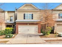 Charming townhouse featuring a brick facade and a two-car garage at 137 Staley Dr, Tucker, GA 30084