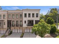 Charming townhome showcasing a brick facade, a covered front porch, and a two-car garage at 210 Marjean Way, Alpharetta, GA 30009