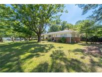 Well maintained home featuring a large front yard with mature trees and a classic brick facade at 2785 Toney Dr, Decatur, GA 30032