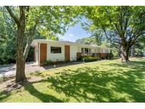 Charming single-story home with brick accents and a well-manicured lawn and mature trees at 2785 Toney Dr, Decatur, GA 30032