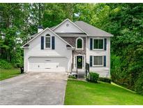 Charming two-story home with stone accents, a well-manicured lawn, and an attached two-car garage at 503 Hearthstone Rdg, Woodstock, GA 30189
