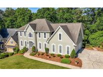 Charming two-story home featuring a manicured lawn, tasteful landscaping, and a welcoming, curved walkway at 3330 Arborwoods Dr, Alpharetta, GA 30022