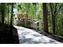 A charming two-story home with a long concrete driveway surrounded by lush greenery at 3820 Fox Creek Ct, Marietta, GA 30062