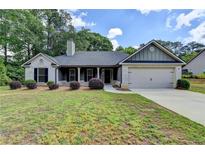 Charming single-story home with gray brick, manicured landscaping, and a two-car garage at 179 Carter Rd, Auburn, GA 30011