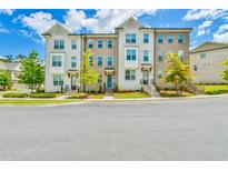Townhome exteriors boast brick and painted facades with well-manicured landscaping and inviting entrances at 3313 Bartee Walk, Suwanee, GA 30024