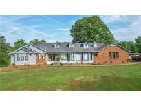 Ranch style home featuring a brick and grey painted exterior, dormer windows, and well maintained landscaping at 2100 Highway 138 E E, Stockbridge, GA 30281