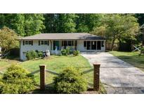 Charming single-story home with a well-manicured lawn and inviting curb appeal and long driveway at 3627 Groovers Lake Rd, Lithia Springs, GA 30122