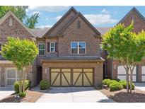 Charming brick townhome featuring a two-car garage and well-maintained landscaping at 4260 Hammond Bridge Dr, Suwanee, GA 30024