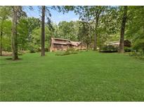 Expansive backyard featuring a well-maintained lawn, mature trees, and inviting landscape at 4615 Gresham Rd, Douglasville, GA 30134