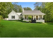Charming single-story home featuring a well-manicured lawn, classic black and white trim, and a cozy front porch at 4615 Gresham Rd, Douglasville, GA 30134