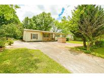 Inviting single-story home with charming front porch and mature trees around the property at 1303 Cochise Cir, Austell, GA 30168