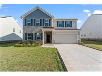Charming two-story home with brick and siding, a well-manicured lawn, and an attached two-car garage at 221 Begonia Way, Mcdonough, GA 30253