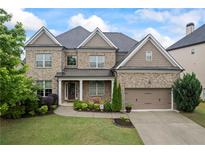Charming brick two-story home featuring a manicured lawn, tidy landscaping and attached two car garage at 4769 Moon Hollow Ct, Buford, GA 30519