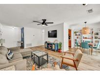 Bright living room with a cozy gray sofa, modern furnishings, and a dining area with stylish blue chairs at 1750 Clairmont Rd # 32, Decatur, GA 30033